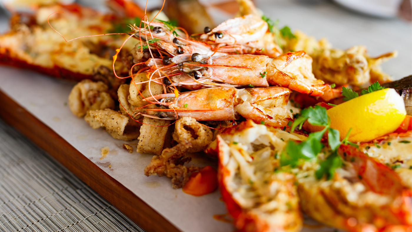 Plated seafood dish with shrimp and lobster on a marble slab
