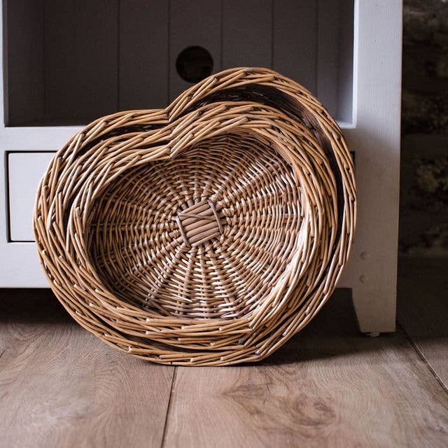 Wicker basket on a wooden floor in front of a white cabinet
