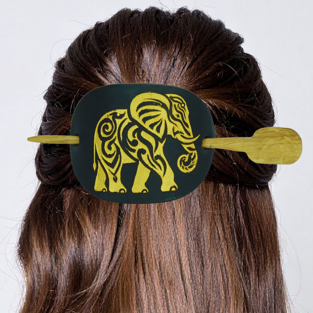 Hair clip with elephant design on a person's hair against a white background