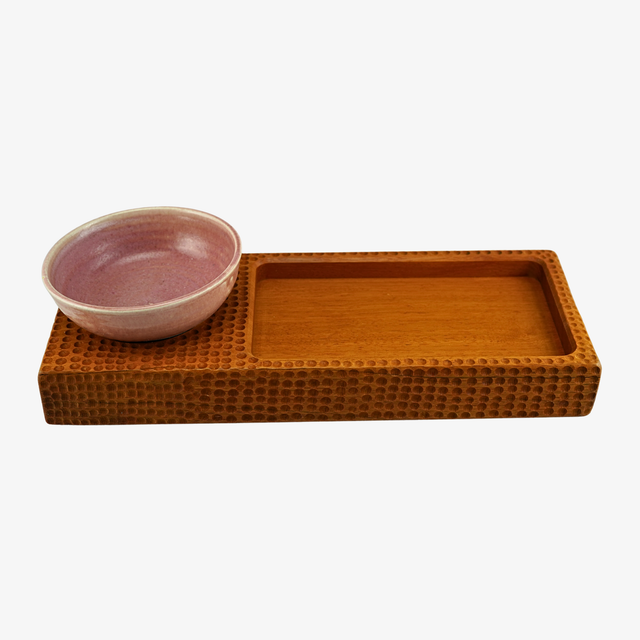 Brown woven tray with a pink bowl on a white background