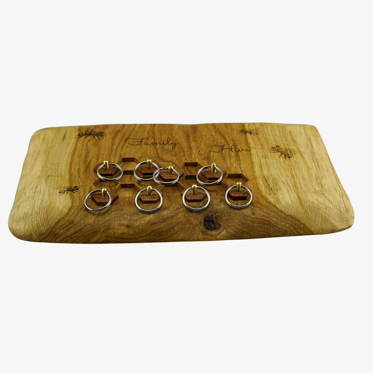 Wooden jewelry display board with engraved text and holes for rings on a white background
