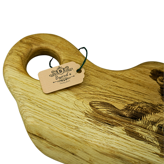 Wooden cutting board with engraved design and Byard's tag on a white background