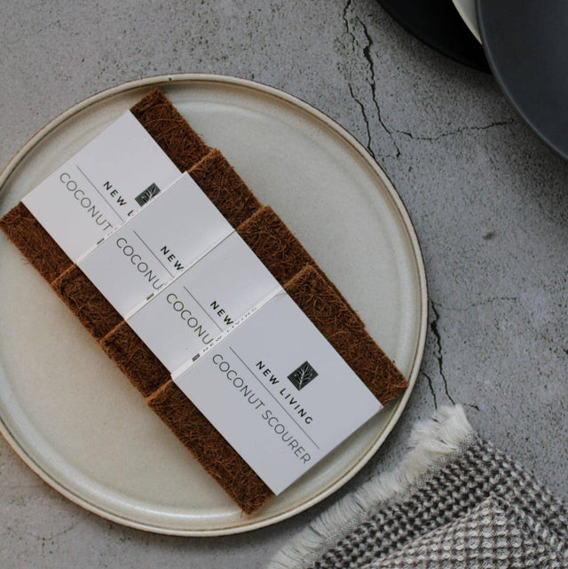 Coconut scrubber set on a plate with business cards on a textured surface