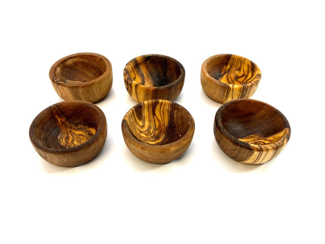 Set of six wooden egg cups with natural patterns on a white background