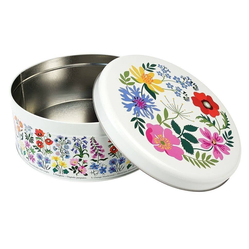 A round metal tin with a white lid decorated with a colourful floral pattern, shown on a plain white background.