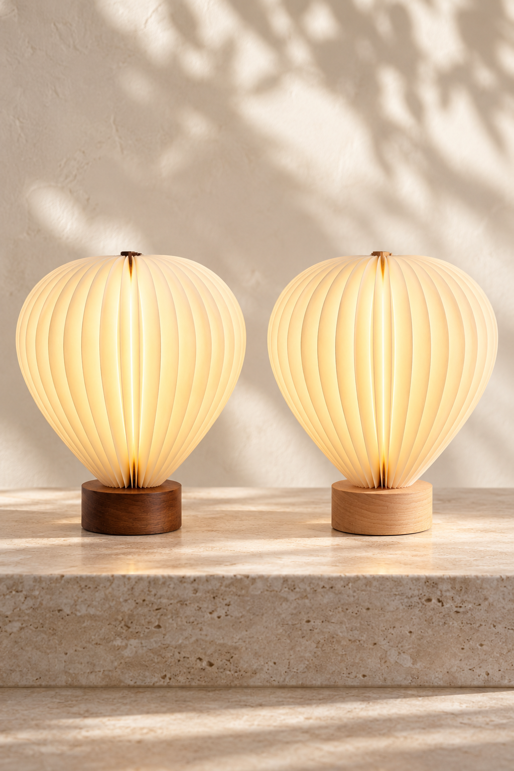 Illuminated Aeris hot air balloon lamp with natural beech wood base on a cream shelf beside books and a vase