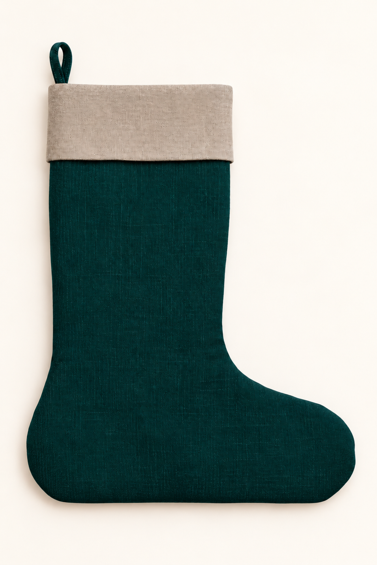 A dark forest green linen Christmas stocking with a contrasting natural linen fabric cuff and a hanging loop, shown against a plain off-white background.