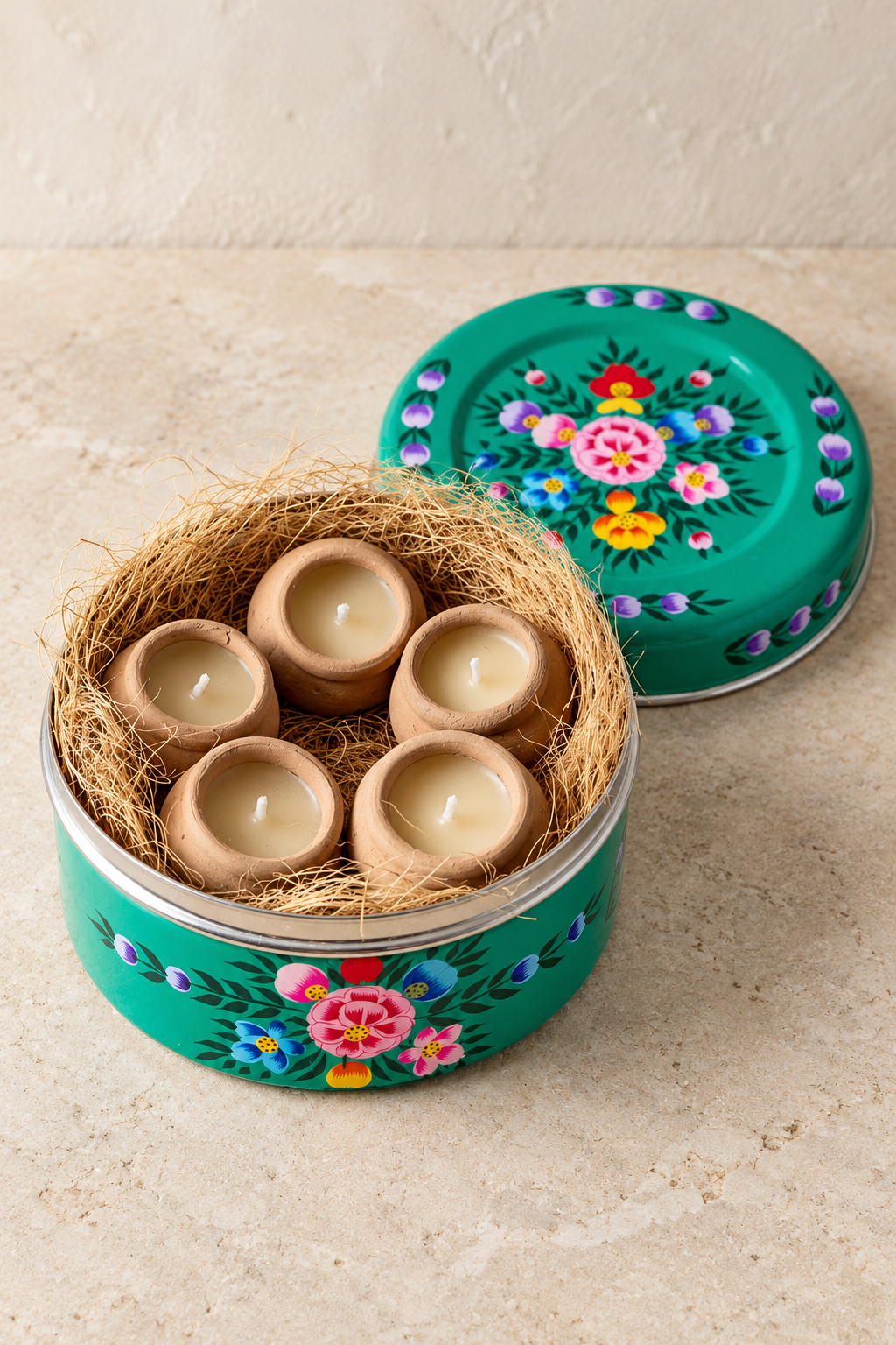 A floral tin to leave on show and five little candles to enjoy. Hand-painted in Kashmir, this green stainless steel container holds lavender-scented candles with a subtle hint of vanilla, hand-poured into terracotta pots. Reuse the empty tin for biscuits, sewing essentials or keepsakes