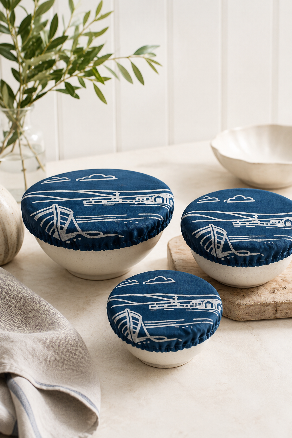 Set of 3 reusable Fjære Coastal linen bowl covers, hand printed in Derbyshire with a coastal design inspired by shoreline huts and beached boats. Made with a 100% linen outer and lined with ProCare® FoodSAFE waterproof fabric. Designed as a reusable alternative to cling film and disposable wraps for covering leftovers, salads, fruit bowls, prep bowls and rising dough.