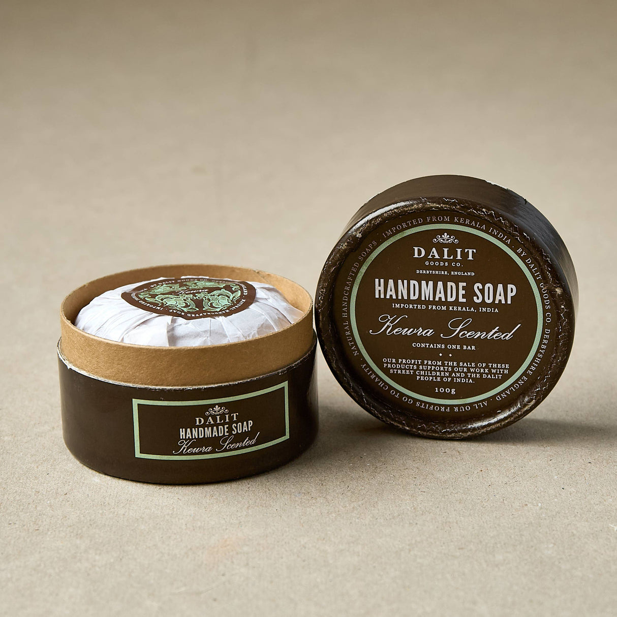 Handmade soap Keira scented in a round container with a label on a beige background