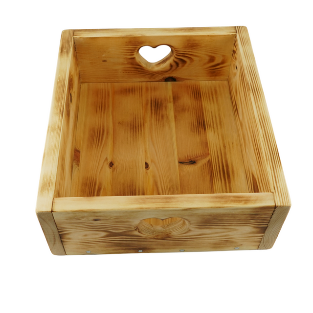 A rustic wooden tray with heart-shaped cut-out handles and floral detailing on the sides.