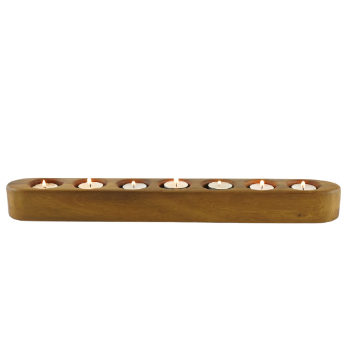 A rectangular oak holder with seven carved recesses, each holding a tea light candle, placed against a white background.