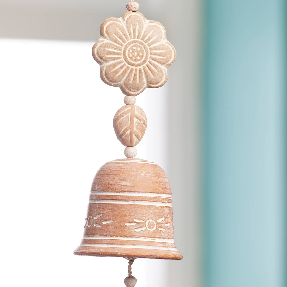 Decorative bell hanging against a light blue wall