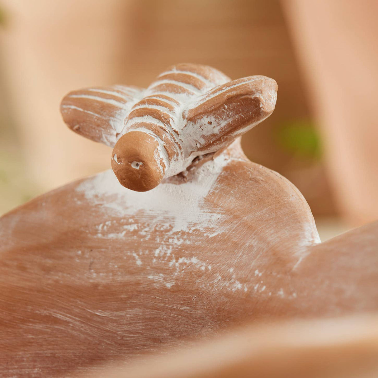 Close up of bee detail on terracotta bowl