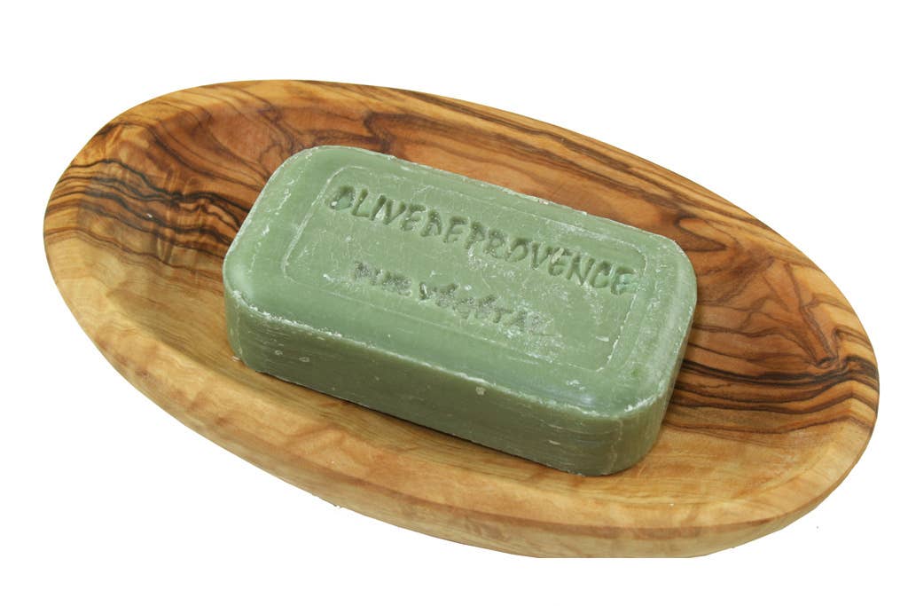 Green bar of soap on a wooden soap dish with 'Oliven Provence' branding.