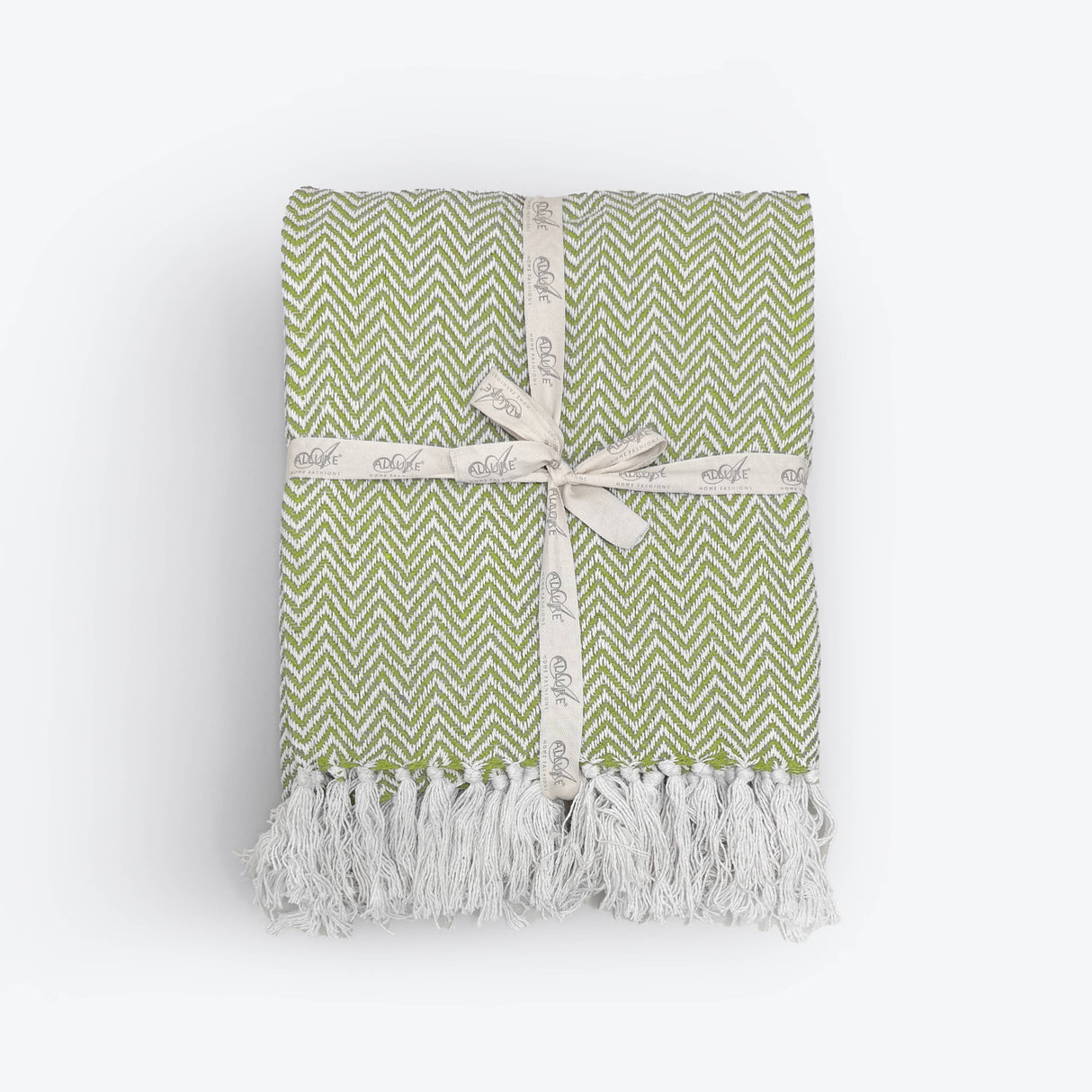 Green and white patterned blanket with tassels on a white background