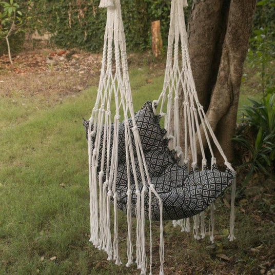 Hanging chair with patterned cushion in a natural outdoor setting