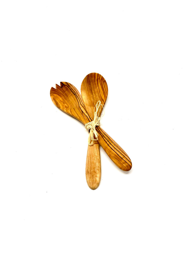 Wooden salad servers with a decorative bow on a white background