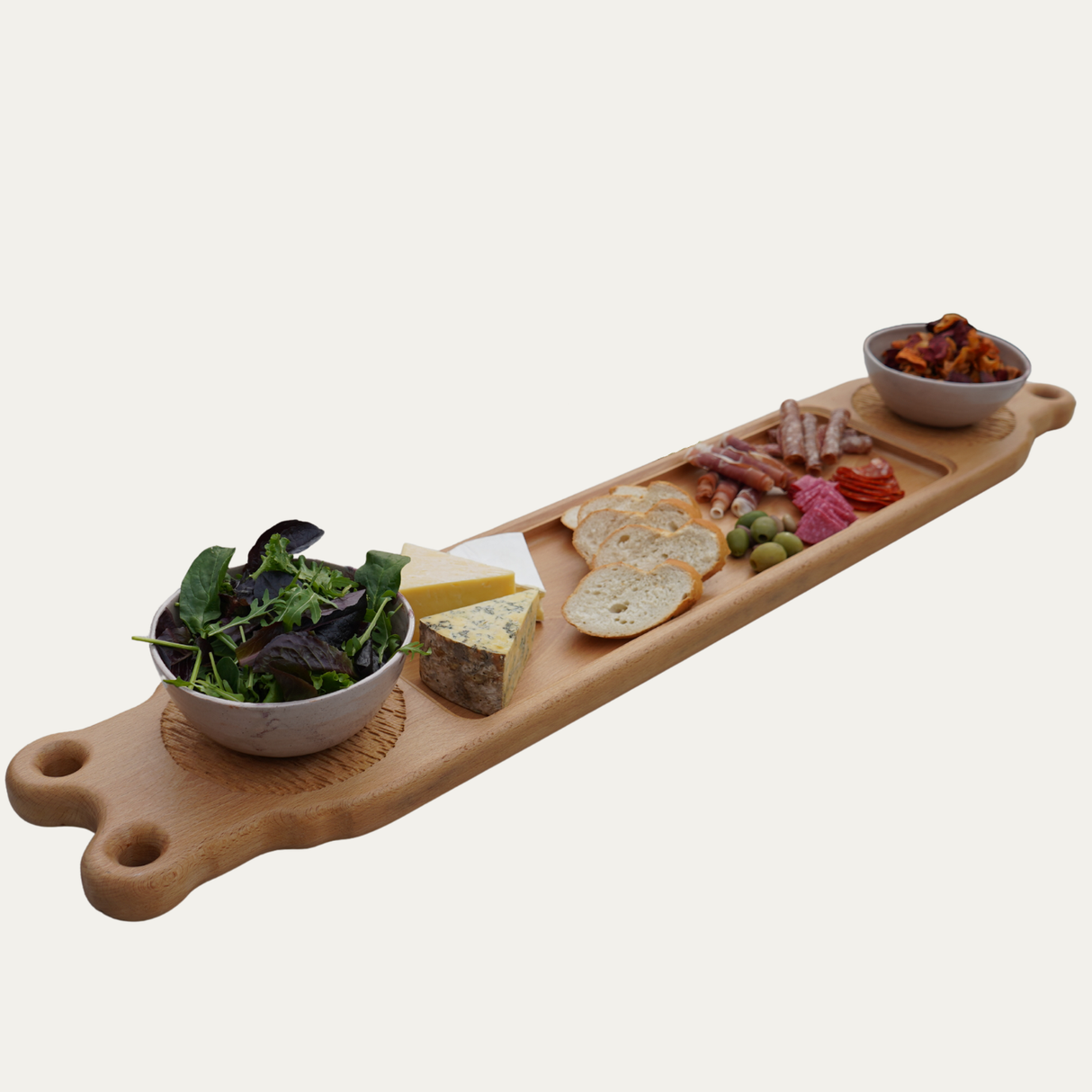 Wooden charcuterie board with various food items on a white background