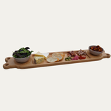Wooden charcuterie board with assorted foods on a white background