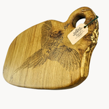 Wooden cutting board with engraved design and brand tag on a white background