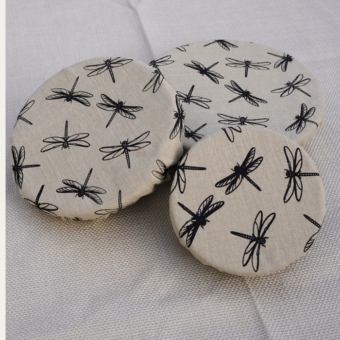 linen bowl covers with black dragonfly patterns on a textured surface