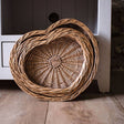 Wicker basket on a wooden floor in front of a white cabinet