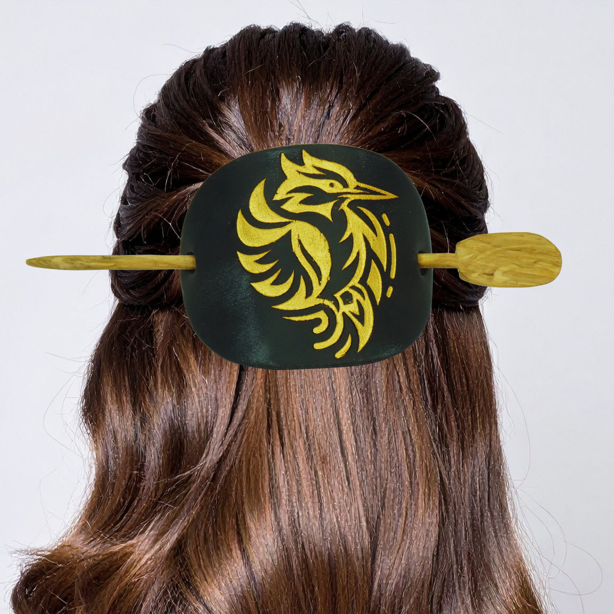 Hair clip with yellow dragon design on a white background