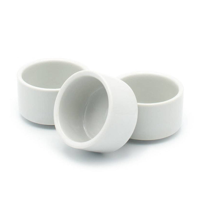 Three white egg cup ceramic bowls on a white background