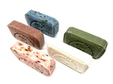 Five different colored soap bars on a white background