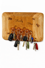 Wooden key holder with keys attached, featuring the word 'Family' and bee illustrations.