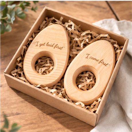 Two wooden rings with engraved text in a box on a wooden surface.