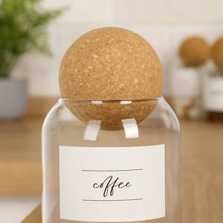 Glass bottle with cork lid labeled 'coffee' on a blurred background