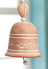 Decorative terracotta bell with white patterns on a light background