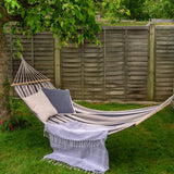 Hammock with striped fabric and pillows in a garden setting