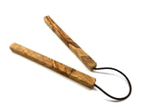 Wooden trivet with a black cord on a white background