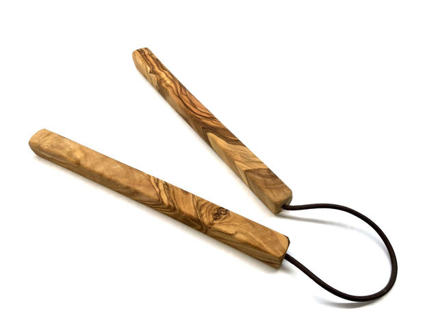 Wooden trivet with a black cord on a white background