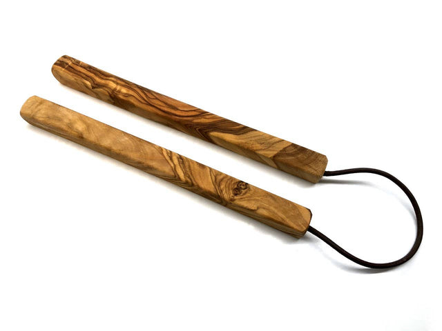 wooden trivet with black cords on a white background