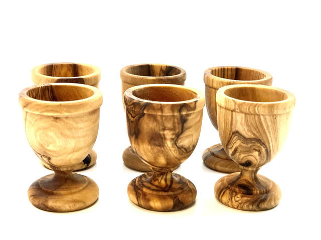 Set of six wooden egg cups with a marbled pattern on a white background