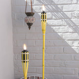 Two yellow torches with flames against a white brick wall.