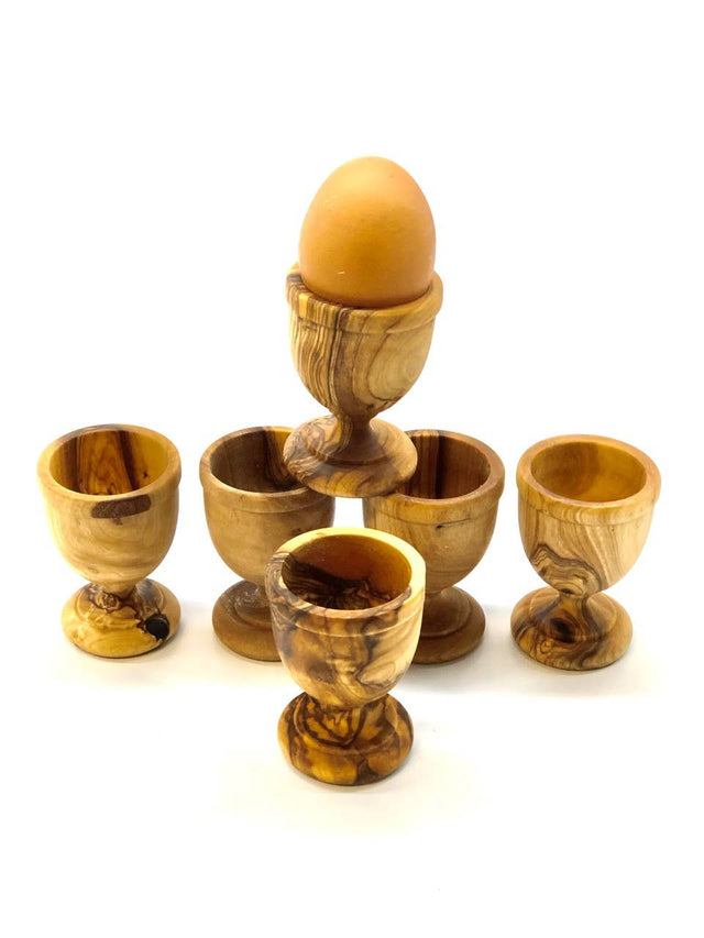 Set of wooden egg cups with a brown egg on a white background