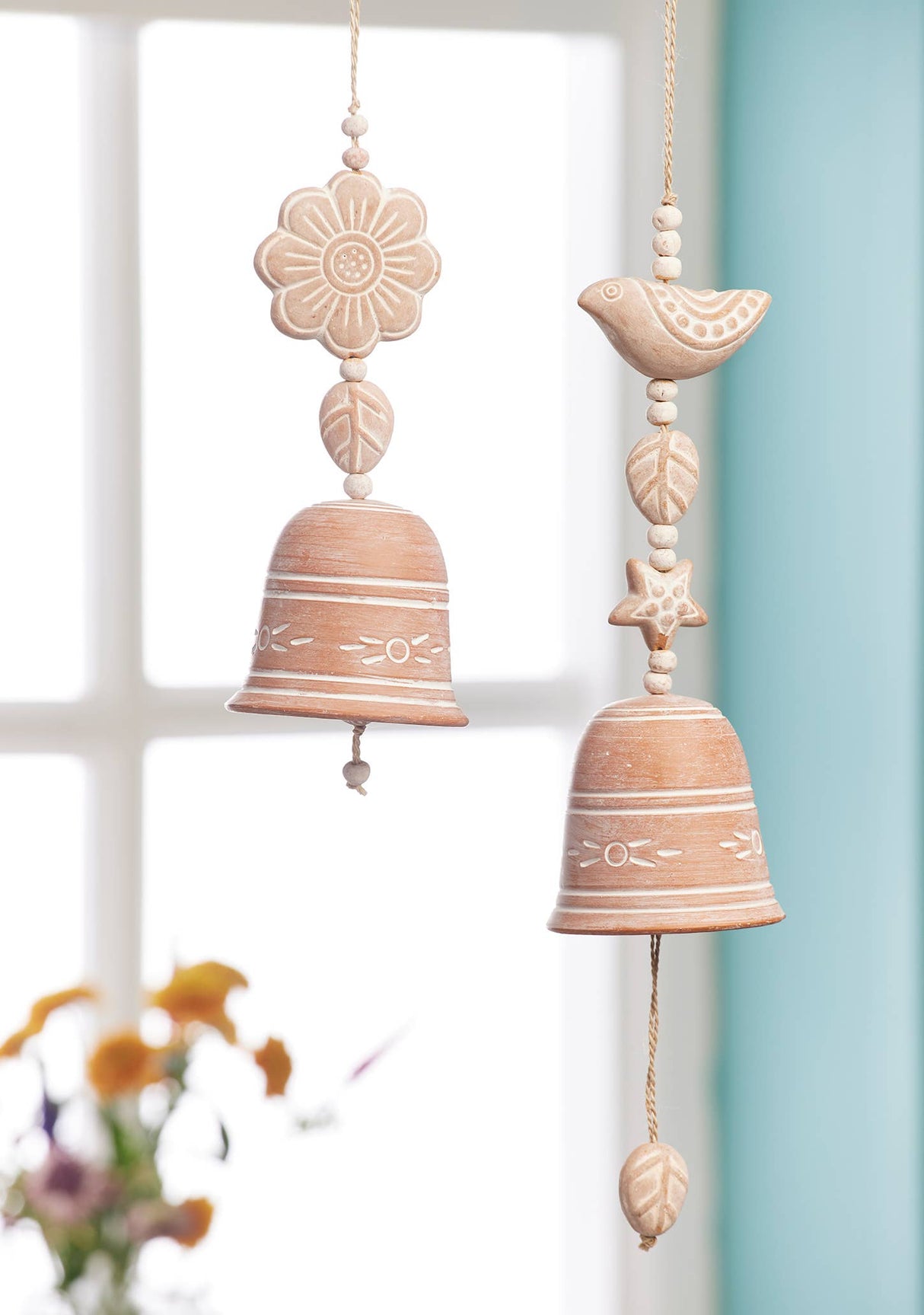 Decorative wind chime with ceramic elements against a light background