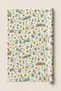 A roll of wrapping paper featuring a vintage-style watercolor pattern of women in white sitting on park benches with flowers, leaves, and medical-themed items, shown against a light beige background.