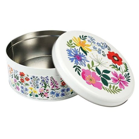 A round metal tin with a white lid decorated with a colourful floral pattern, shown on a plain white background.