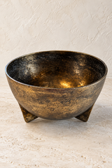 Poseidon antique gold metal bowl on three fin-shaped feet, showing its wide opening and mottled finish against a pale background.