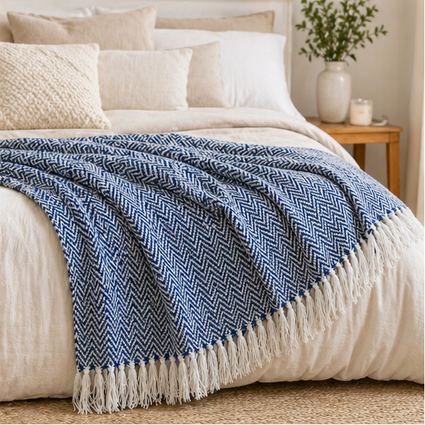 Blue herringbone blanket with white fringe displayed in various settings.