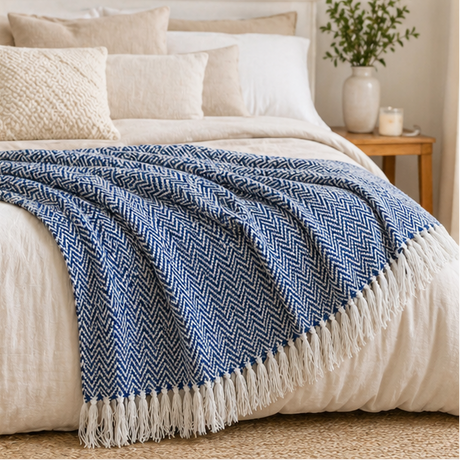 Blue herringbone blanket with white fringe displayed in various settings.