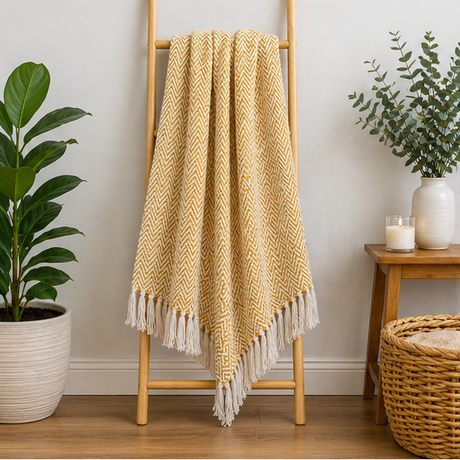 Yellow blanket with white fringe displayed over a ladder.