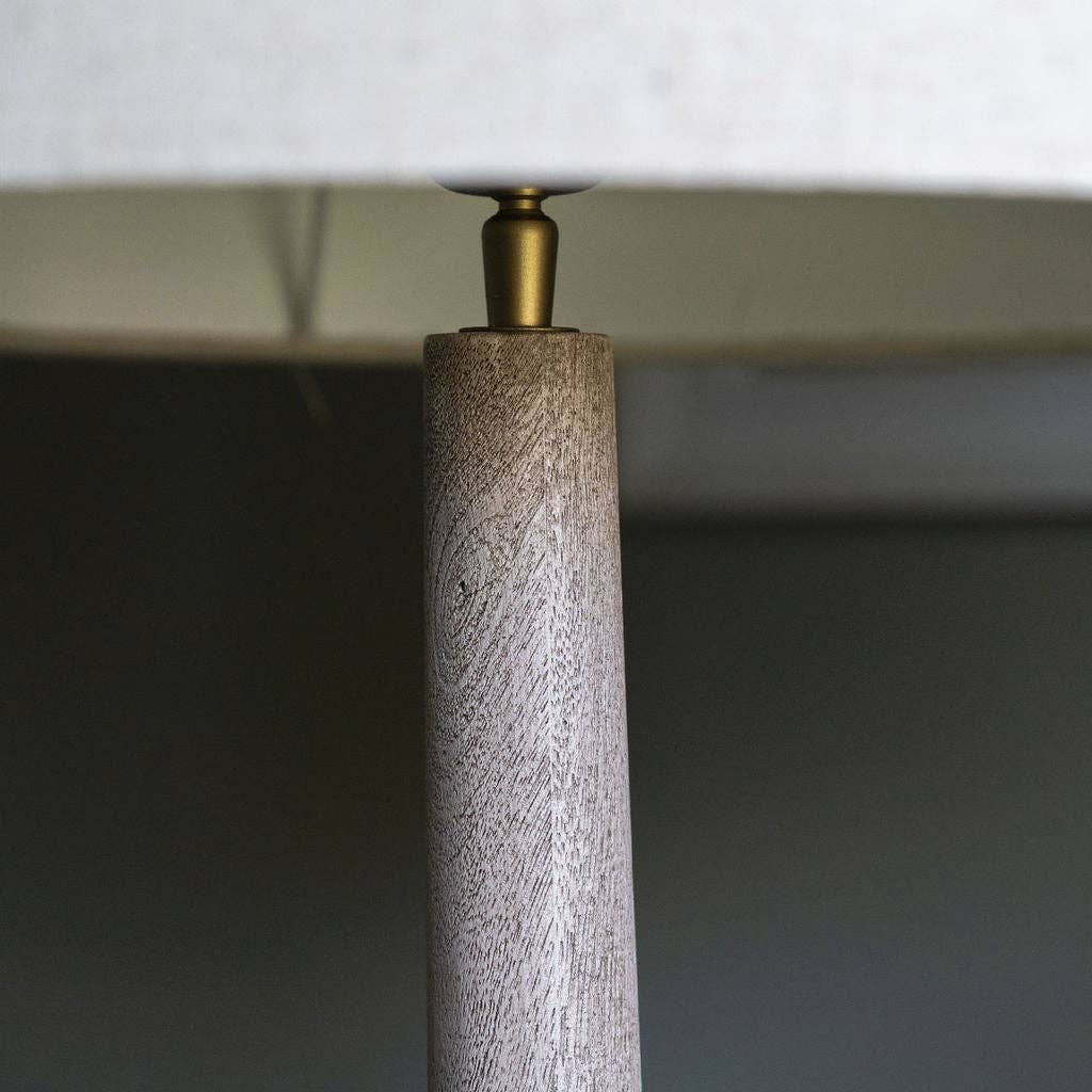 Close-up of a lamp with wooden base and metallic fitting against a dark background