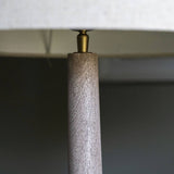 Close-up of a lamp with wooden base and metallic fitting against a dark background